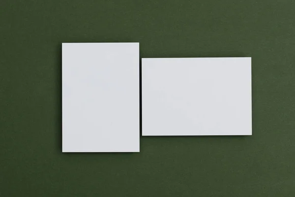 Cartão postal branco em branco sobre um fundo verde — Fotografia de Stock