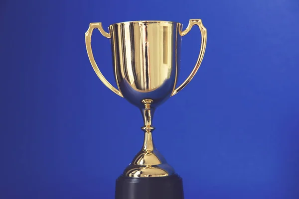 Gold winners trophy cup on a blue background