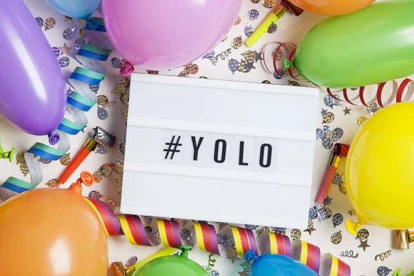라이트 박스 위 에서 YOLO 메시지로 축하 파티 배경 — 스톡 사진