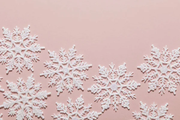 Composición de copo de nieve de brillo blanco sobre un fondo rosa pastel — Foto de Stock