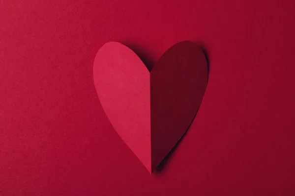 Красная бумага любит сердце на обычном красном фоне. День святого Валентина — стоковое фото