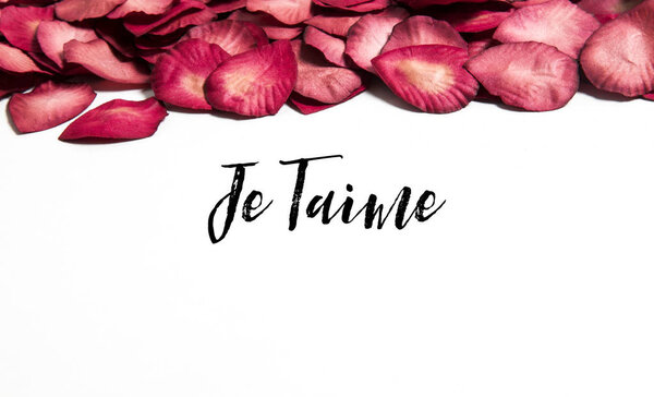 Red rose petals with je taime message