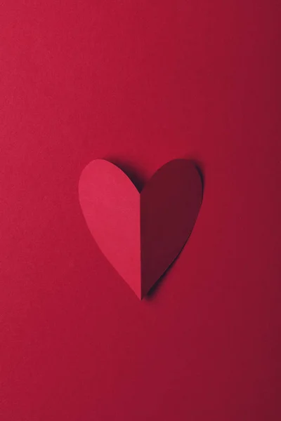 Красная бумага любит сердце на обычном красном фоне. День святого Валентина — стоковое фото