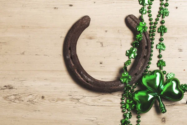 Lucky horse shoe with St Patrick 's day green clover decorations — стоковое фото