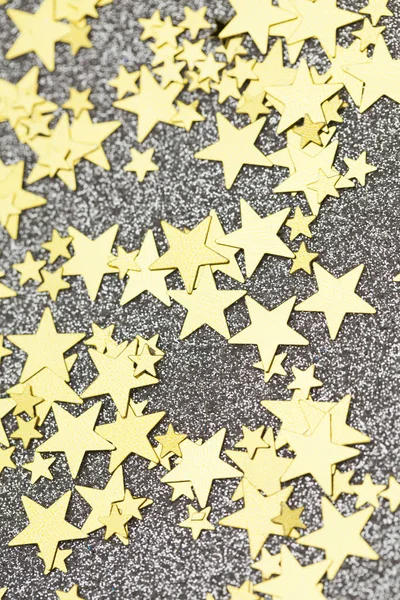Gold star confetti on a silver glitter background. festive holid