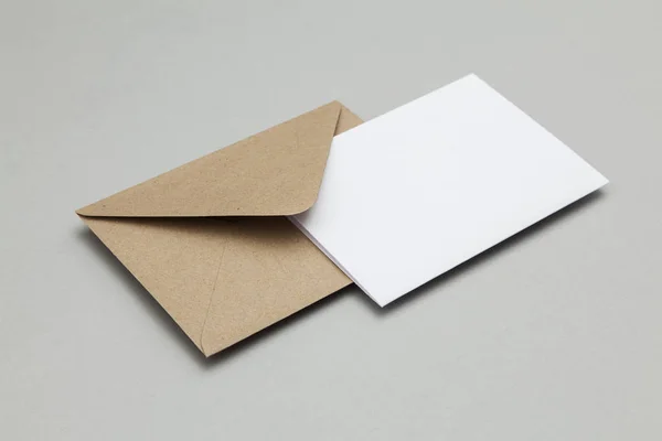 Tarjeta blanca en blanco con plantilla de sobre de papel marrón kraft maqueta u —  Fotos de Stock
