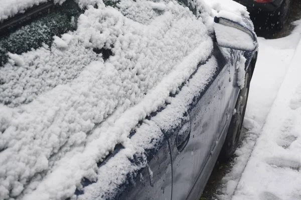 Un coche cubierto de nieve después de una tormenta de invierno —  Fotos de Stock