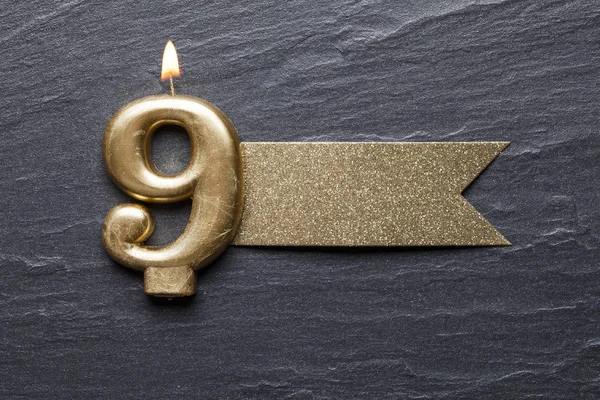 Parlak etiketli 9 numaralı kutlama mumu.