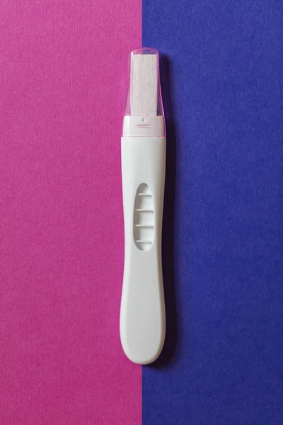 Tes kehamilan pada latar belakang biru dan merah muda — Stok Foto