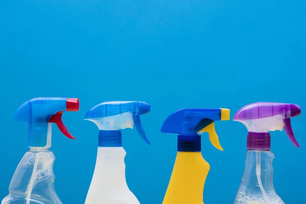 Membersihkan produk botol semprotan dengan latar belakang biru cerah — Stok Foto