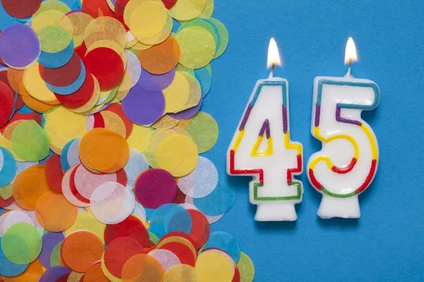 Číslo 45 slavnostní svíčka s party konfety — Stock fotografie