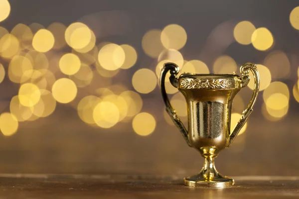 Troféu de prêmio de ouro contra luzes embaçadas brilhantes — Fotografia de Stock