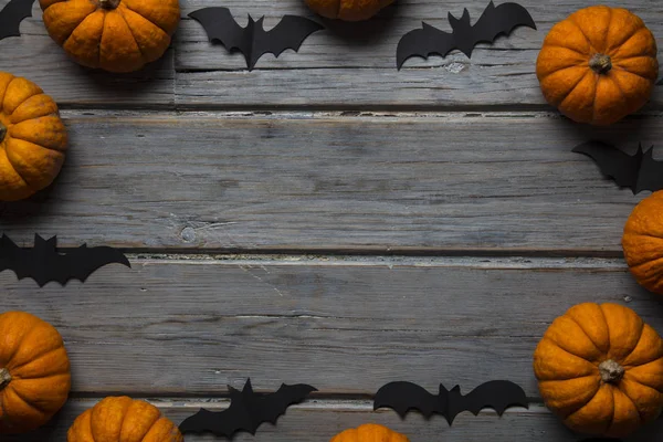 Cadılar Bayramı balkabakları ve tahta arka planda kara vampir yarasalar