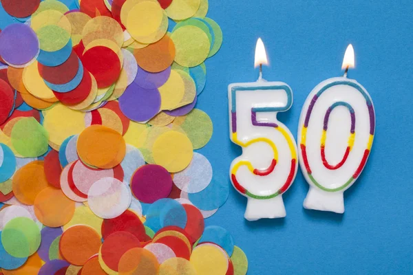 Number 50 celebration candle with party confetti Royalty Free Stock Photos