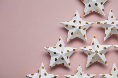 Pastel pembe üzerine beyaz ve altın yıldız süslemeleri. Mevsimlik fetiş