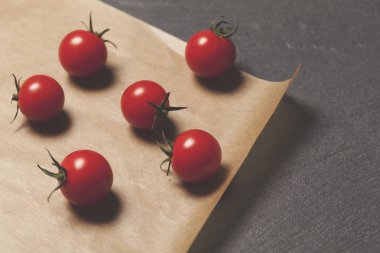 Kahverengi kağıtta taze vişne asması domatesleri.