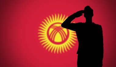 Kırgızistan bayrağına selam veren bir askerin silueti