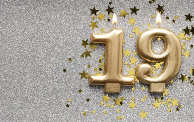 Yıldız ve ışıltılı arka plan üzerinde Sayı 19 altın kutlama mum