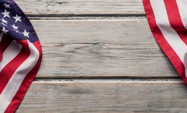 Amerikan yıldızları ve çizgileri beyaz ahşap bir döşemede bayrak sallıyor.