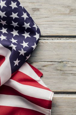 Amerikan yıldızları ve çizgileri beyaz ahşap bir döşemede bayrak sallıyor.