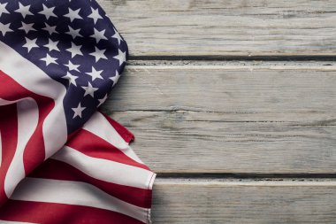 Amerikan yıldızları ve çizgileri beyaz ahşap bir döşemede bayrak sallıyor.