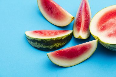 Parlak mavi arka planda taze dilimlenmiş karpuz.