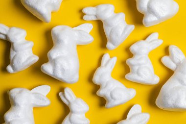 Parlak sarı arka planda Paskalya tavşanları