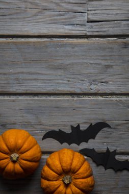 Cadılar Bayramı balkabakları ve tahta arka planda kara vampir yarasalar