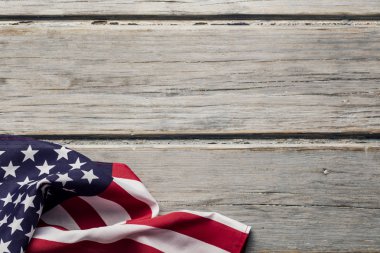 Amerikan yıldızları ve çizgileri beyaz ahşap bir döşemede bayrak sallıyor.