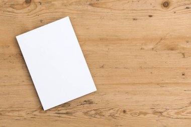 Tahta bir arka planda boş bir kartpostal ilanı.