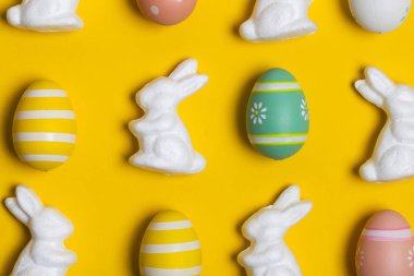 Parlak sarı arka planda Paskalya tavşanı ve yumurtalar