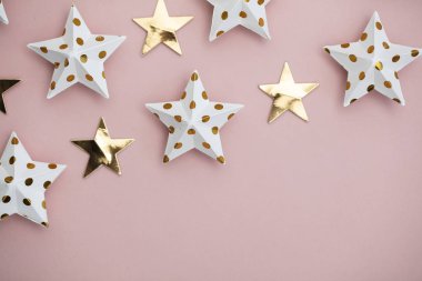 Pastel pembe üzerine beyaz ve altın yıldız süslemeleri. Mevsimlik fetiş