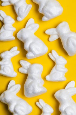 Parlak sarı arka planda Paskalya tavşanları