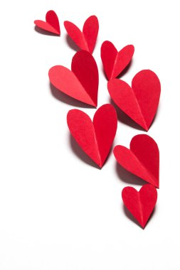 Beyaz arka planda kırmızı el yapımı kağıt kalpler.