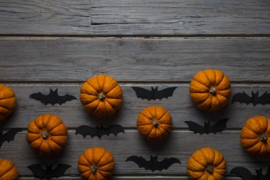 Cadılar Bayramı balkabakları ve tahta arka planda kara vampir yarasalar