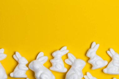 Parlak sarı arka planda Paskalya tavşanları