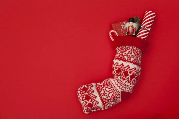 Рождественский чулок с крекером, игрушкой и завернутым подарком — стоковое фото