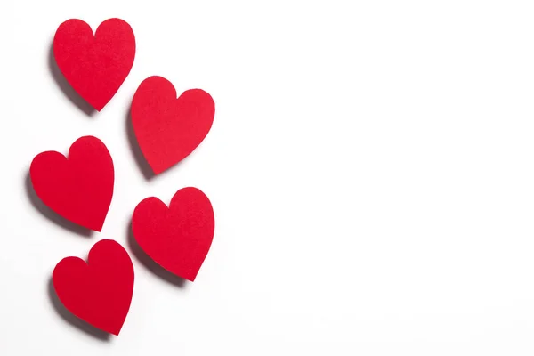 Rode handgemaakte papieren hartjes op een witte achtergrond — Stockfoto