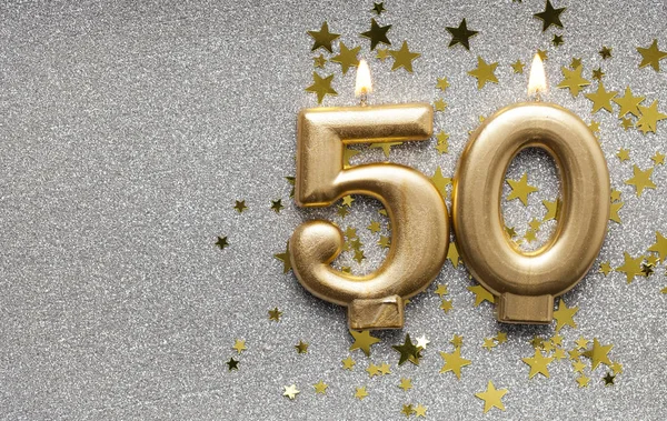 Number 50 gold celebration candle on star and glitter background — Stock Photo, Image