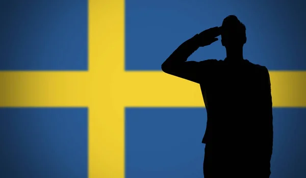 Egy katona sziluettje, aki a svéd zászló előtt tisztelegett. — Stock Fotó