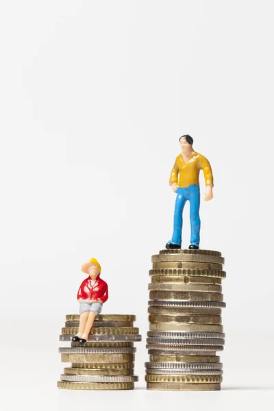 男女の賃金平等の概念。コインの積み重ねの上の男女. — ストック写真