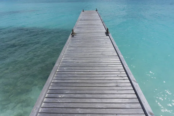 Houten pier over helderblauwe zee — Stockfoto