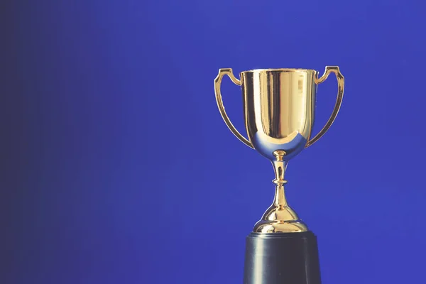 Gold winners trophy cup on a blue background