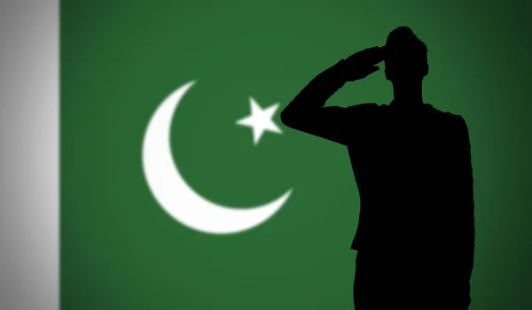 Silhouette eines Soldaten, der vor der pakistanischen Flagge salutiert — Stockfoto