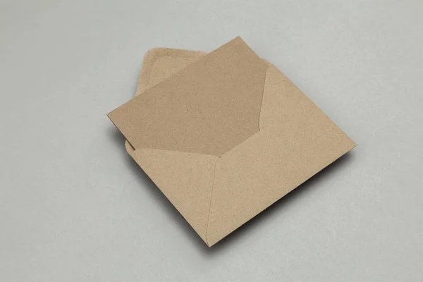 Üres barna kraft papír kártya és boríték szürke alapon — Stock Fotó
