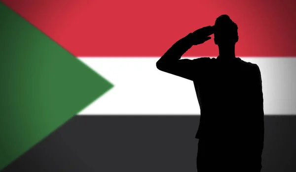 Sudan bayrağına selam veren bir askerin silueti — Stok fotoğraf