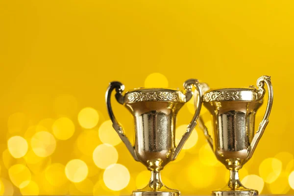 Troféu de prêmio de ouro contra fundo amarelo brilhante com borrado — Fotografia de Stock