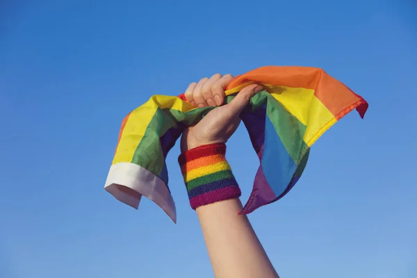 Conceito de orgulho gay. mão segurando um gay orgulho LGBT arco-íris bandeira . — Fotografia de Stock
