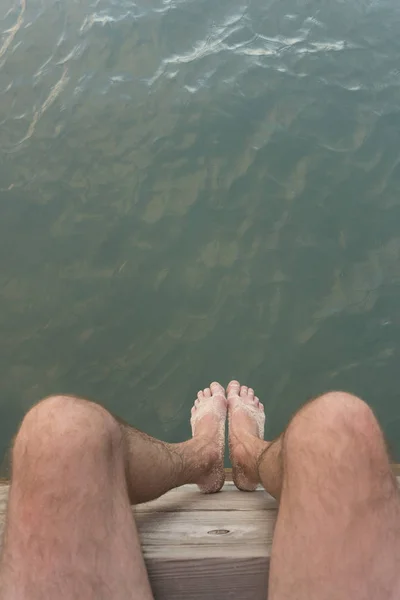 Uomo seduto sul molo sopra l'acqua punto di vista sopraelevato Travel Lif — Foto Stock