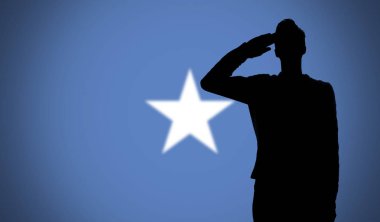 Somali bayrağına selam veren bir askerin silueti.